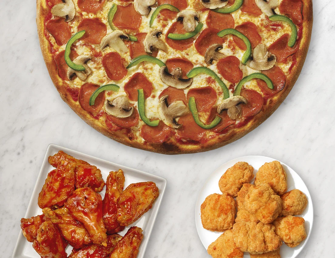 Fresh pepperoni pizza with side order of chicken wings and cheese sticks at Pizzanapoli Lloydminster