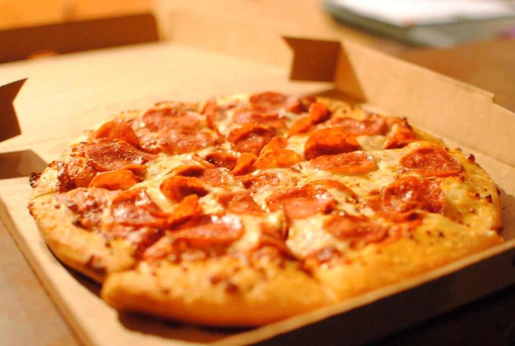 Pepperoni pizza slice with stretchy melted mozzarella cheese at Pizzanapoli Lloydminster
